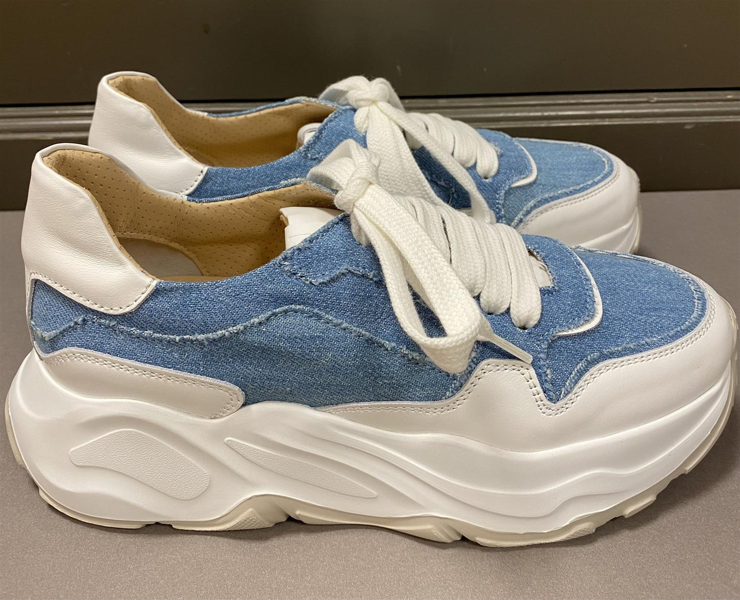 Sneakers med dongeri og skinn.